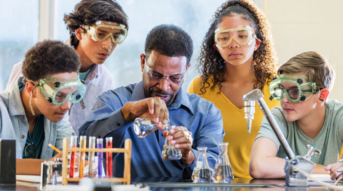 Male-teacher-demonstrating-chemistry-experiment-to-HS-students-700x390